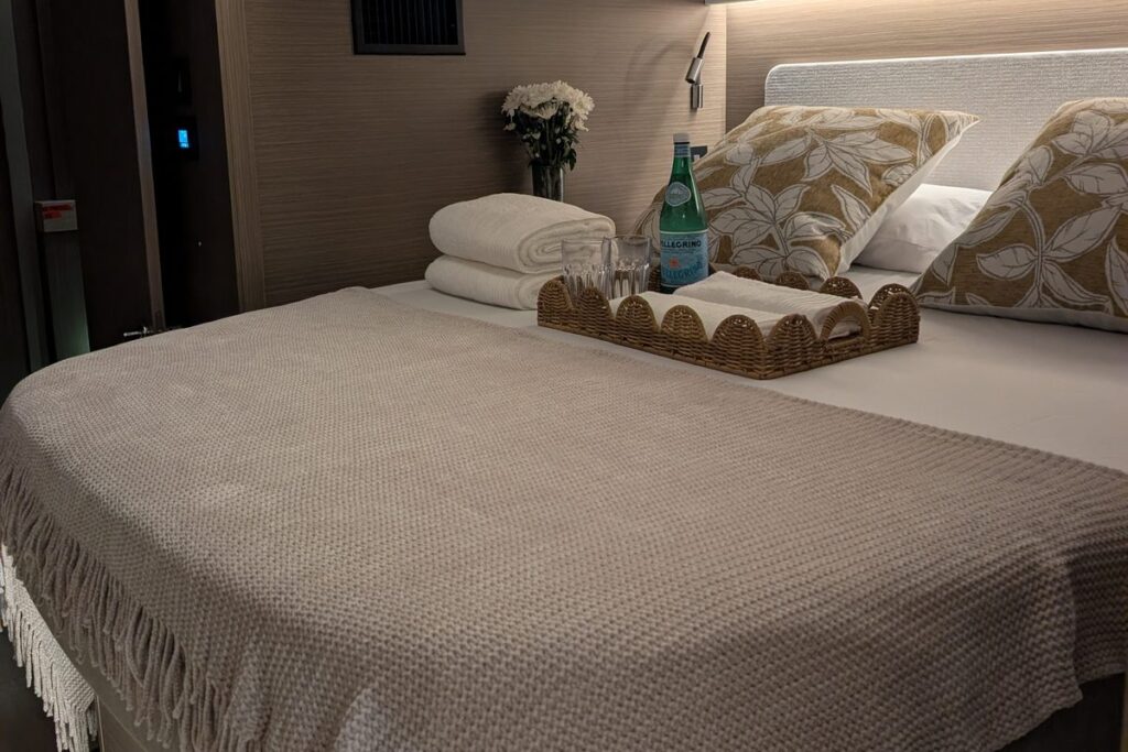 Private double cabin with fresh linen and towels on a crewed catamaran