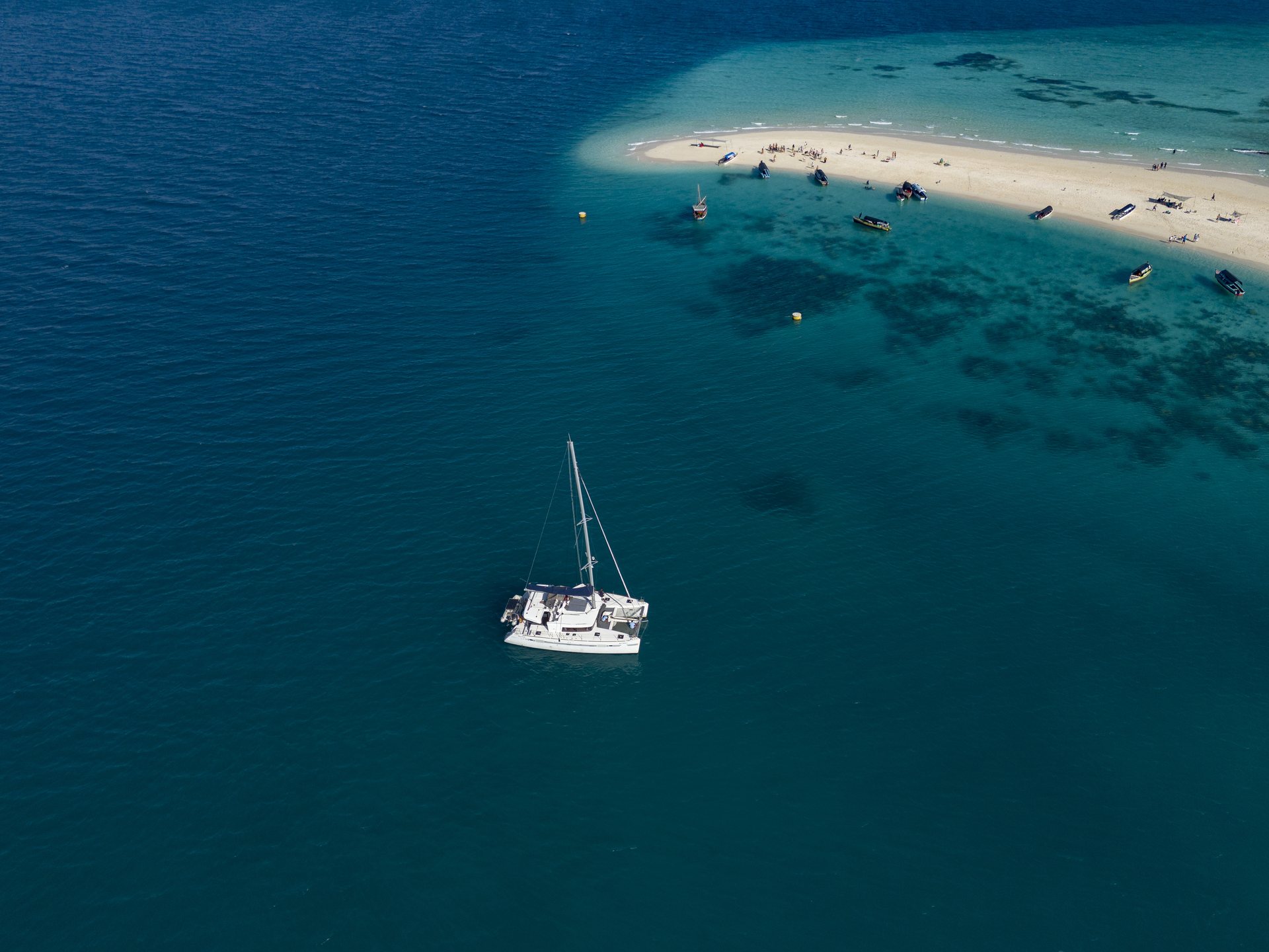 Catamaran anchored by a white sandbank in Zanzibar